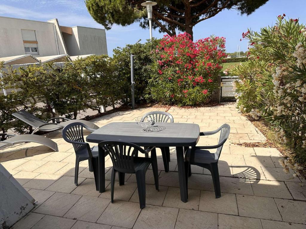 une table noire et des chaises sur une terrasse dans l'établissement Appartement 3 pièces, terrasse privée, 6 personnes à Port Camargue - FR-1-731-120, au Grau-du-Roi