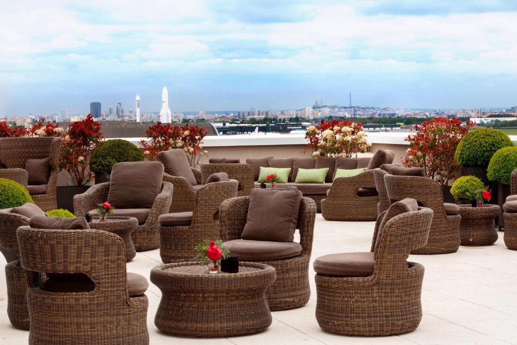 a group of wicker chairs and chairs on a roof at AC Hotel by Marriott Paris Le Bourget Airport in Le Bourget