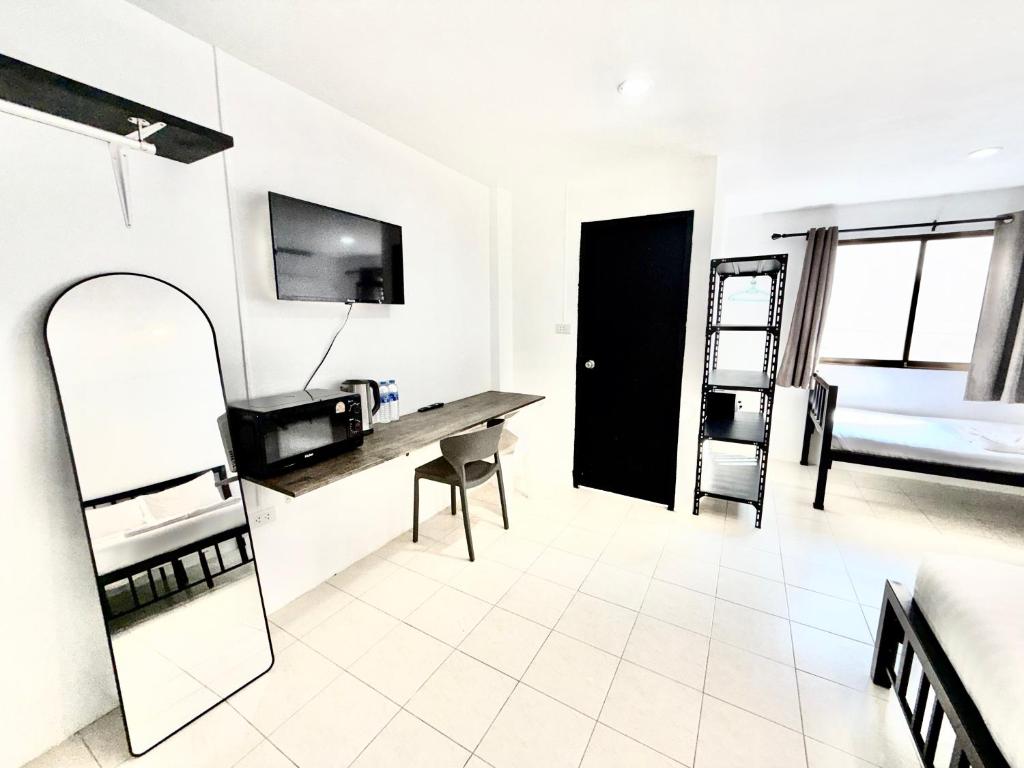 a white room with a desk and a bed at Patong Canal Villa 208 in Patong Beach
