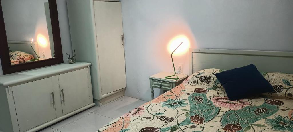 ein Schlafzimmer mit einem Bett, einer Lampe und einem Spiegel in der Unterkunft Departamento y Alberca privada in Yelateni