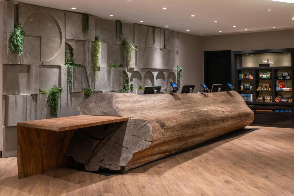 a large wooden table in a lobby with a large log at Hotel Paradox, Autograph Collection in Santa Cruz