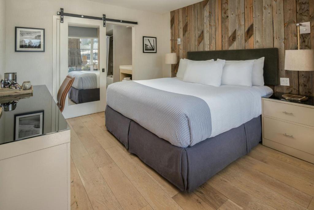 a bedroom with a large bed and a kitchen at Hotel Paradox, Autograph Collection in Santa Cruz