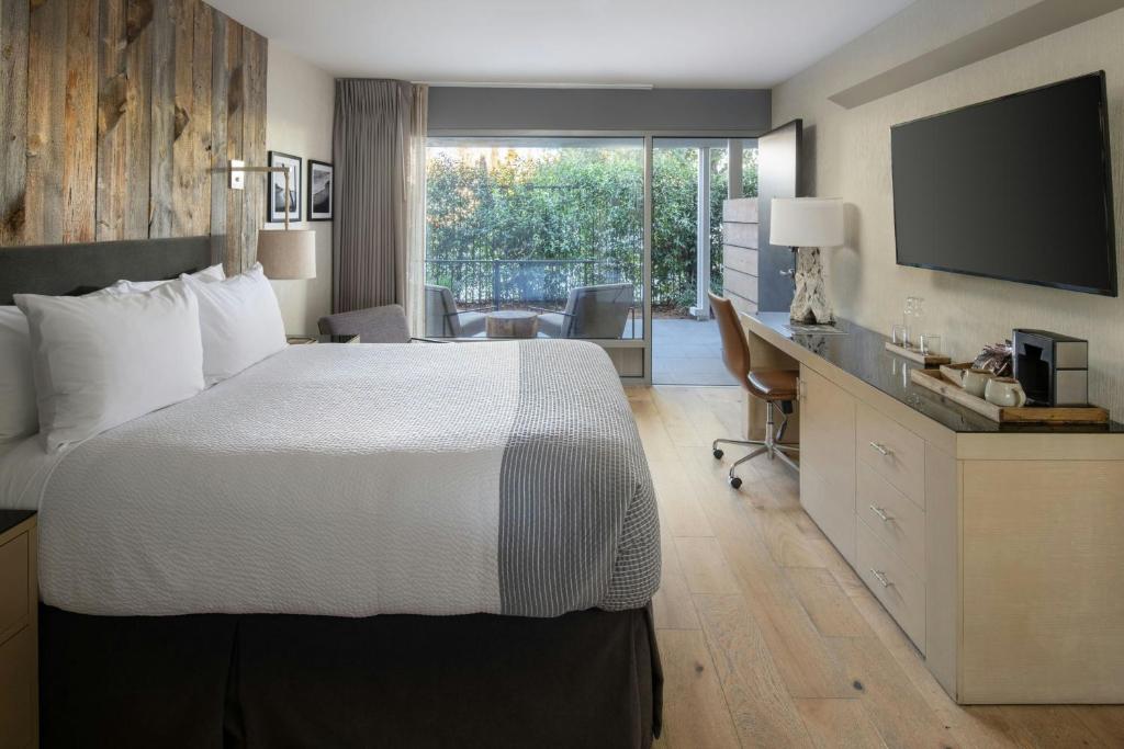 a hotel room with a bed and a desk with a television at Hotel Paradox, Autograph Collection in Santa Cruz