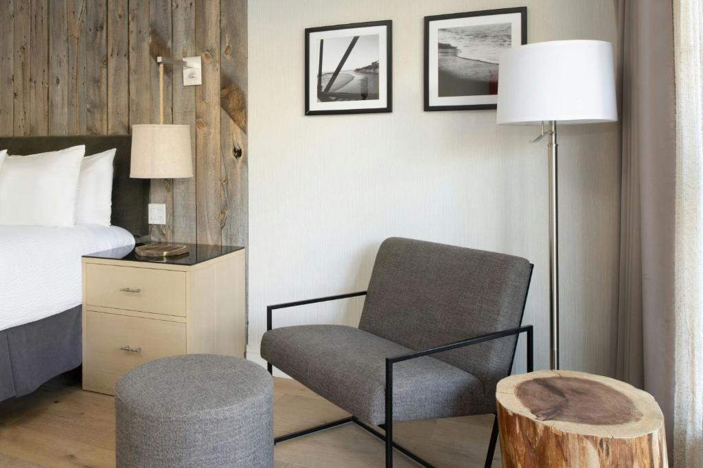 a bedroom with a bed and a chair and a lamp at Hotel Paradox, Autograph Collection in Santa Cruz
