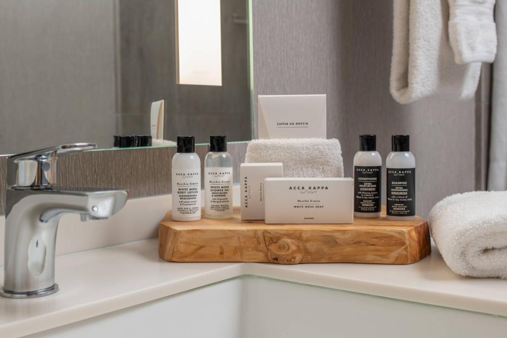 a bathroom counter with bottles of soap and towels at Hotel Paradox, Autograph Collection in Santa Cruz
