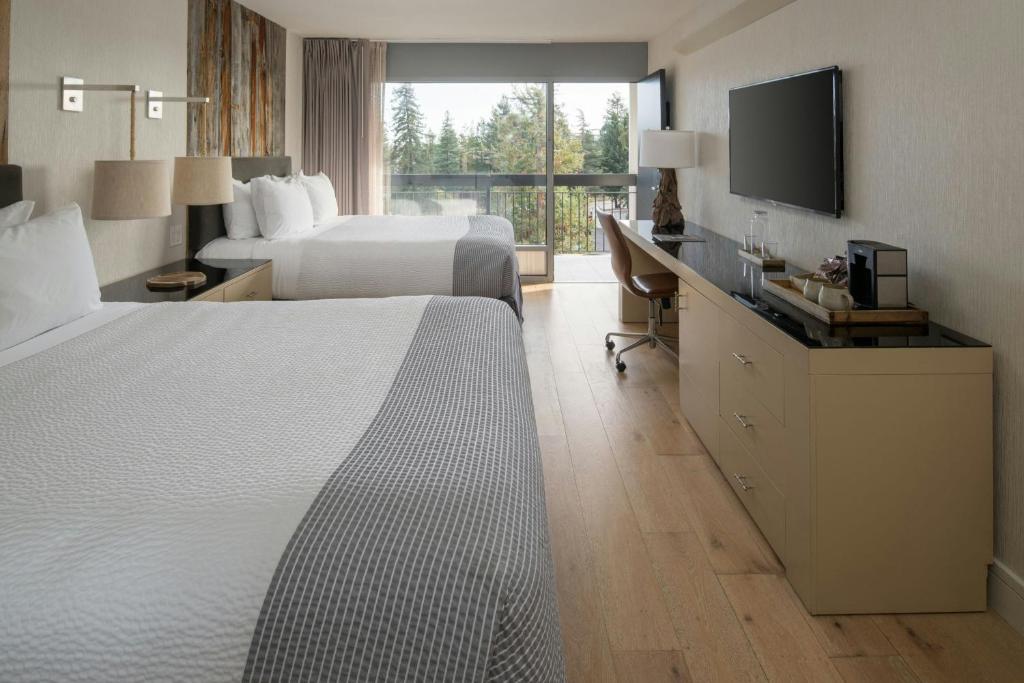 a hotel room with two beds and a flat screen tv at Hotel Paradox, Autograph Collection in Santa Cruz