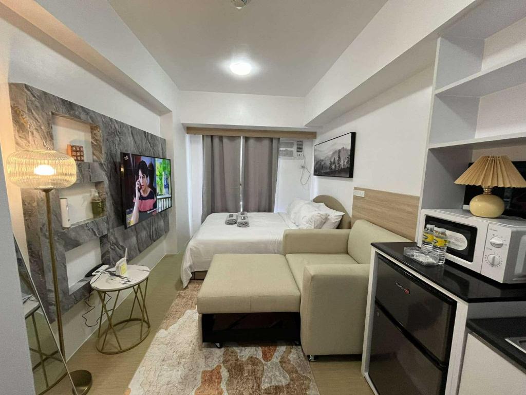 a living room with a bed and a couch in a room at Premium Affordable Condo by Premium Living in Iloilo City