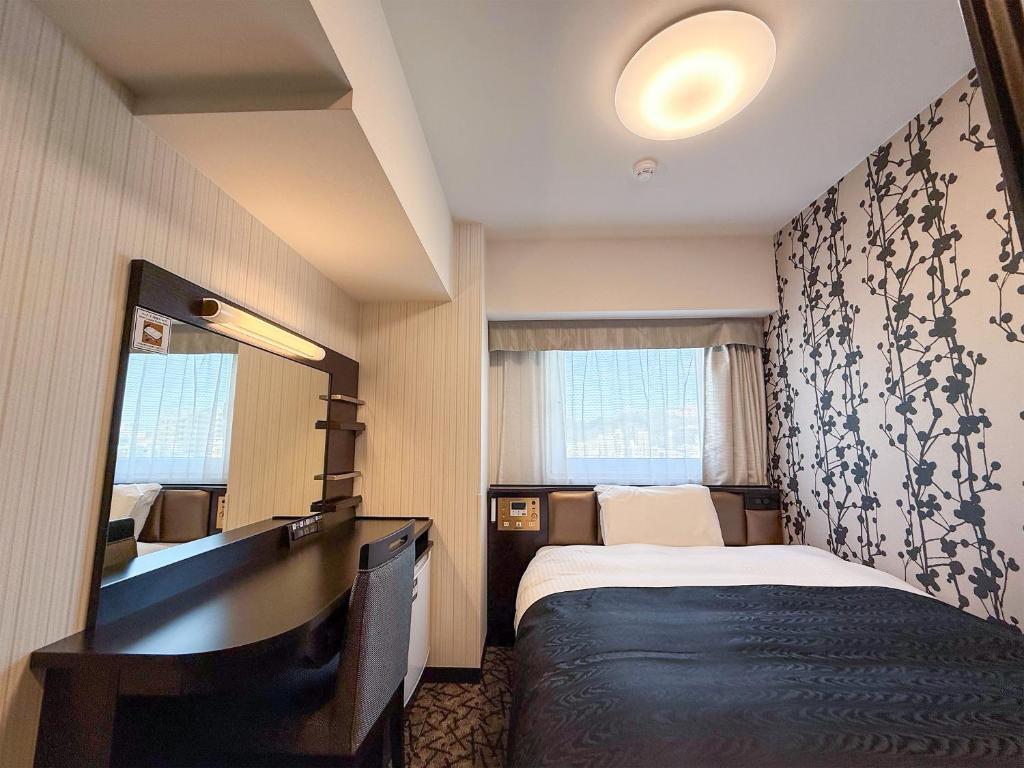 a hotel room with a bed and a mirror at APA Hotel Shibuya Dogenzakaue in Tokyo
