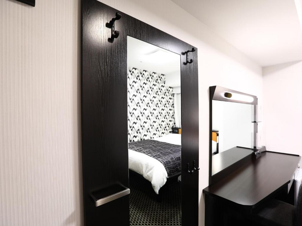 a mirror in a room with a bed and a bedroom at APA Hotel Shibuya Dogenzakaue in Tokyo