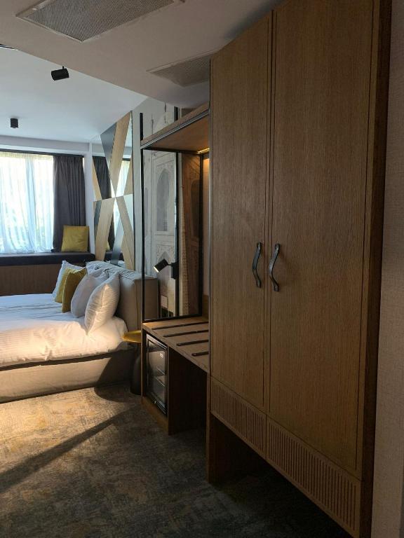 a bedroom with a bed and a wooden cabinet at MM Boutique Hotel in Burgas