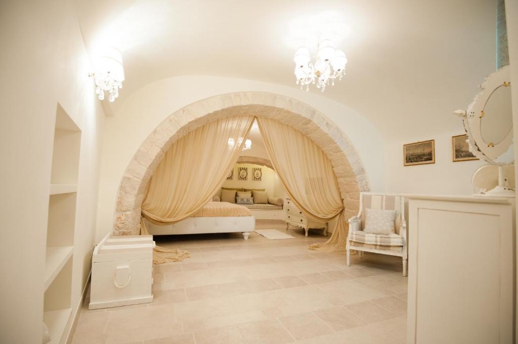 a living room with an archway with a bed and chairs at Gnostre Holidays in Noci