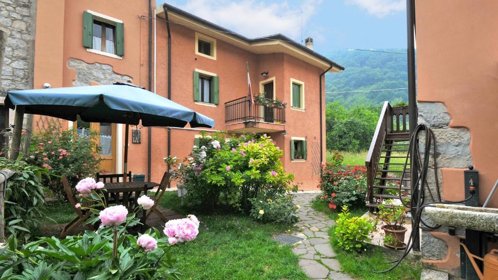 a building with an umbrella and flowers in front of it at La Nicchia in Tarzo