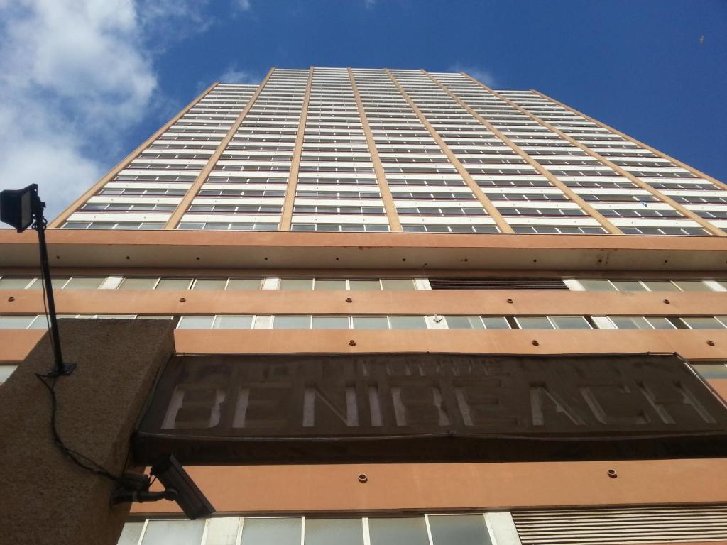 a tall building with a sign in front of it at Apartamentos Beni-Beach in Benidorm