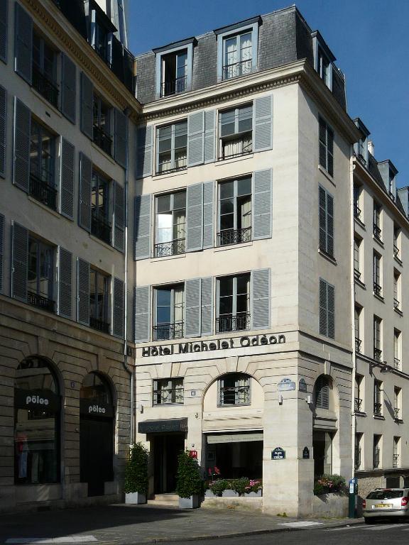 un grand bâtiment blanc avec une enseigne dessus dans l'établissement Hotel Michelet Odeon, à Paris
