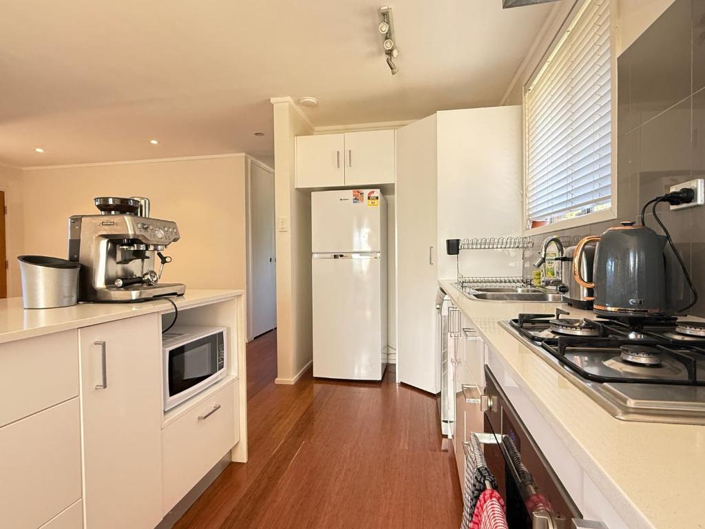 a kitchen with a white refrigerator and a stove at Page 3BR House in Canberra