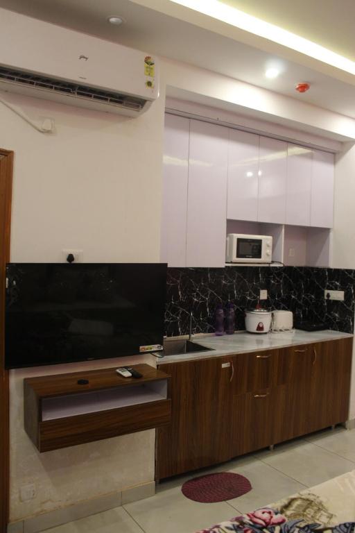 ノイダにあるHome stay a beautiful placeのシンクと電子レンジ付きのキッチン
