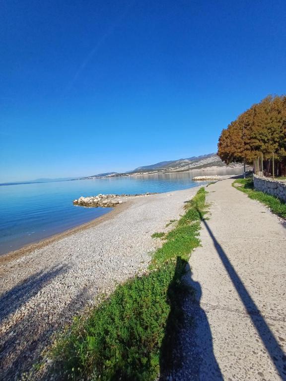 a shadow of a person standing on a beach at Loni in Klenovica