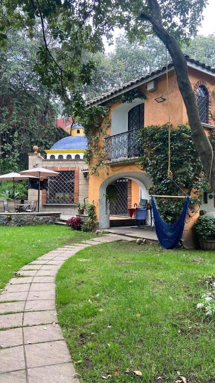 a house with a porch and a hammock in the yard at beautiful house in Mexico City