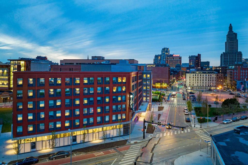 a city skyline at night with a red building at Aloft Providence Downtown in Providence