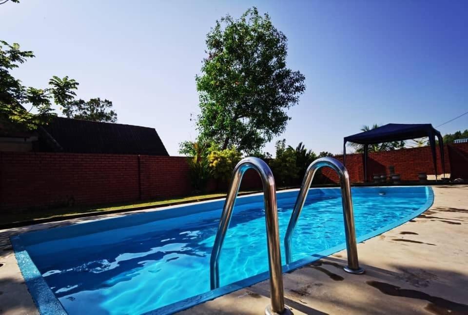 a swimming pool with two metal rails in it at A Famosa Villa 62 with Private Swimming Pool in Kampong Pulau Sebang
