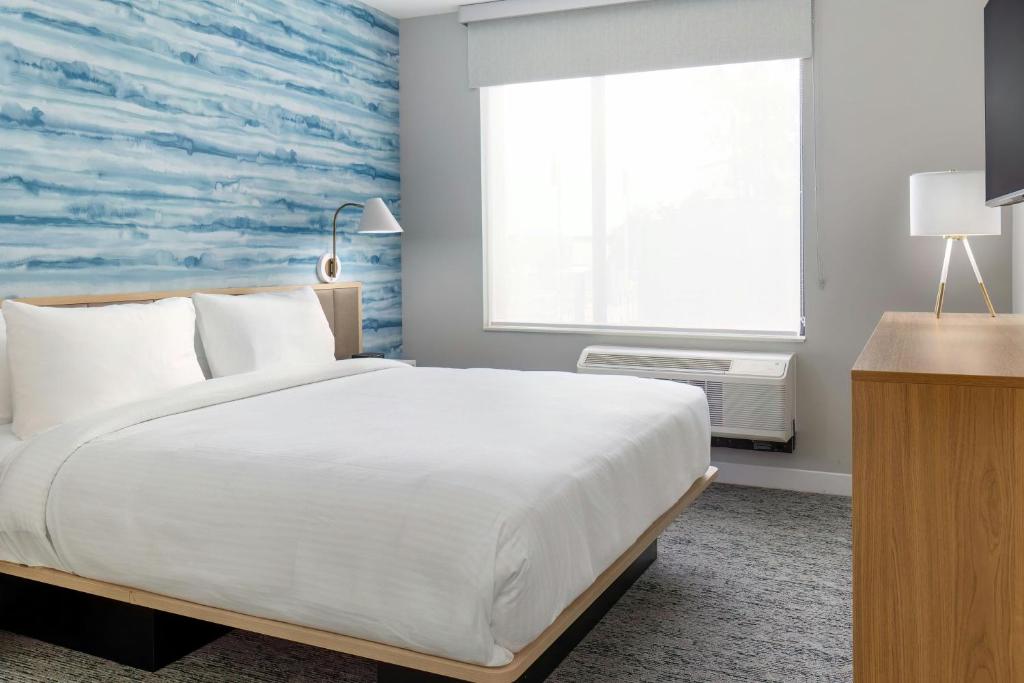 a bedroom with a large white bed and a window at TownePlace Suites by Marriott Monrovia in Monrovia