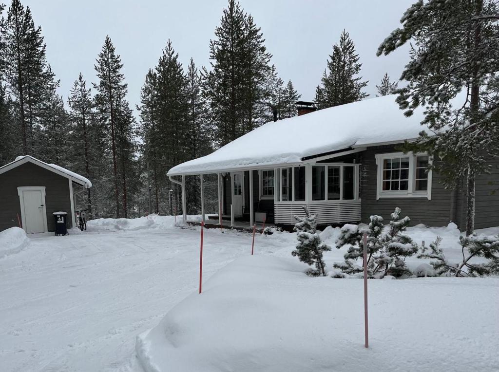 una casa con techo cubierto de nieve en un patio en Villa Porotupa, en Syöte