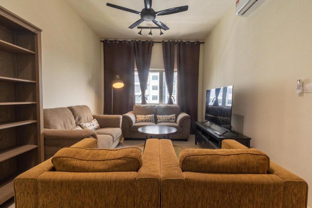a living room with a couch and a ceiling fan at Mat Leo Homestay at MRT Kajang in Kajang