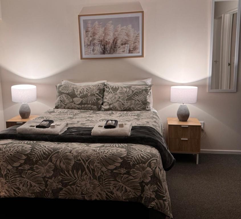 Un dormitorio con una cama con dos lámparas encima. en Wairoa Motel, en Wairoa