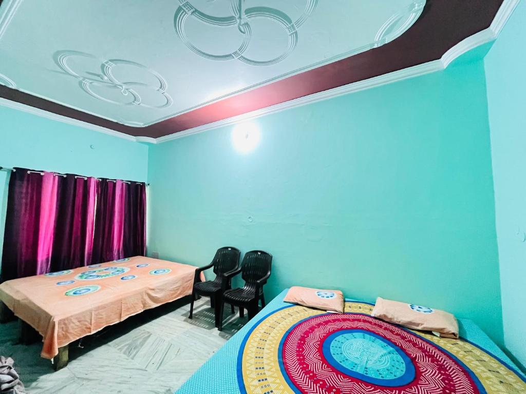 a room with two beds and two chairs in it at Prayag Homestays Cheoki in Prayagraj
