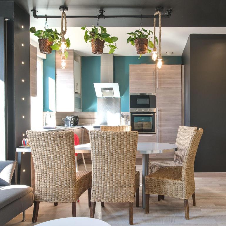une cuisine avec une table et des chaises dans une pièce dans l'établissement UnSejourAMetz - Gite Metz Chapelle, 3 chambres & Garage, à Metz