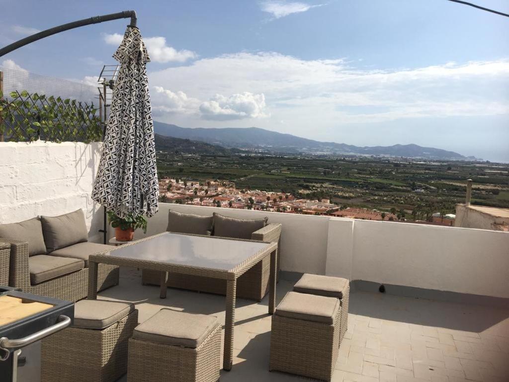 a patio with a table and chairs on a balcony at Casa Tropical in Salobreña