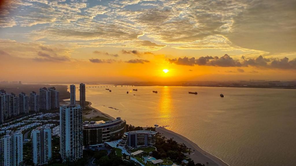 ゲラン・パタにあるCarnelian Tower Hotel at ForestCity 4108 with WIFIの海岸と海を望む街の夕日