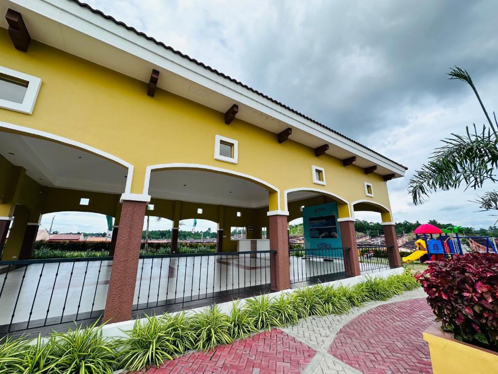 a yellow building with a fence next to a playground at Camella Homes near Airport 2 bedrooms in Davao City