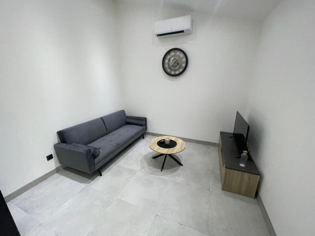 un salon avec un canapé et une table dans l'établissement Maison à la campagne au bord de la ville, à Préguillac