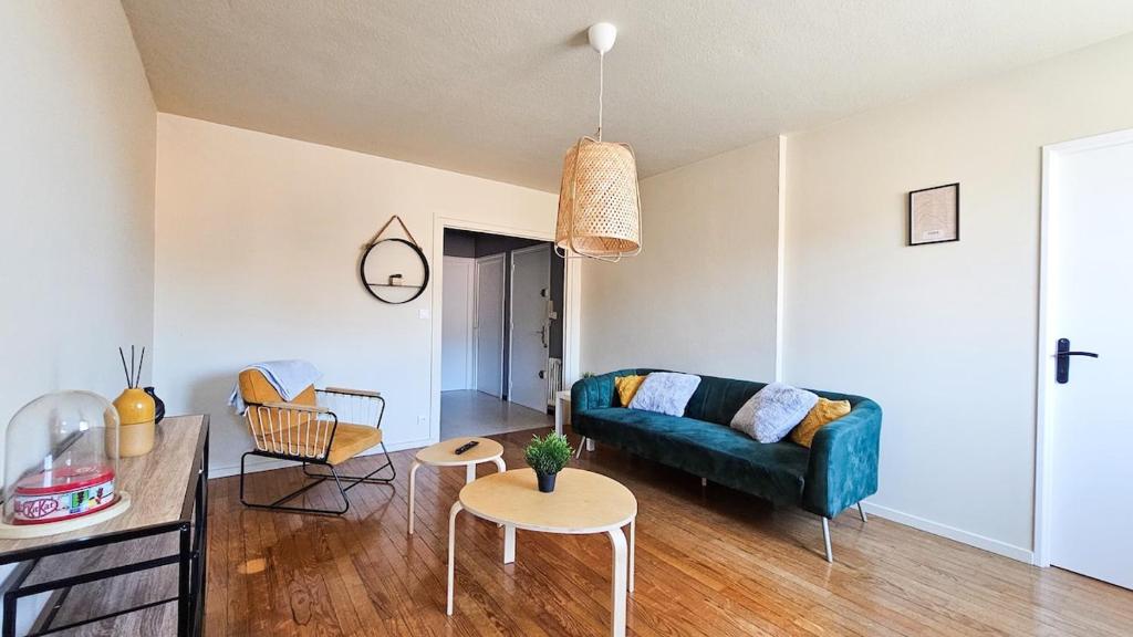 un salon avec un canapé et une table dans l'établissement La Comète 4 Bedroom WiFi TV, à Saint-Étienne