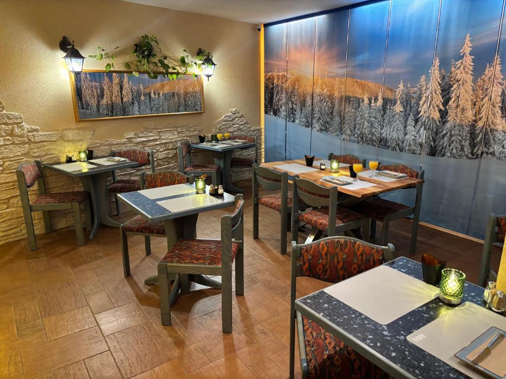 un ristorante con tavoli e sedie in una stanza di Ambiente Hotel Strehla a Strehla
