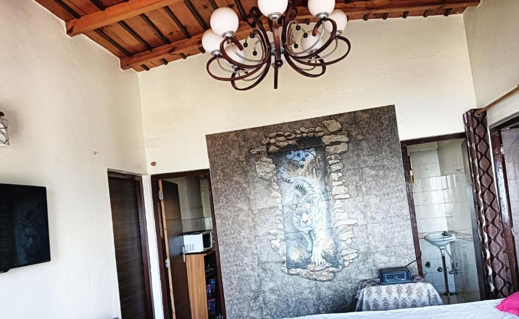 Una lámpara de araña colgando de una pared en un dormitorio. en Ghorakhal Homestay, en Nainital