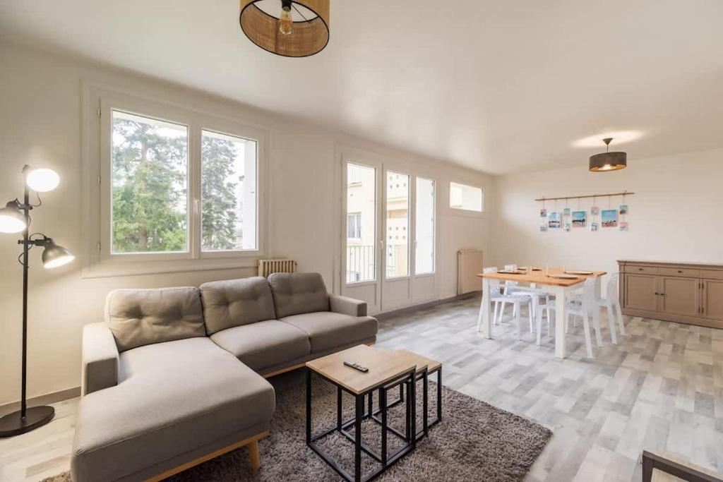 un salon avec un canapé et une table dans l'établissement Grand appartement proche gare de Guingamp, à Guingamp