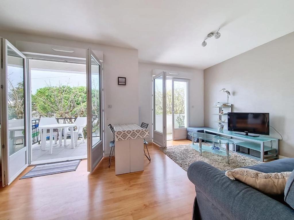 un salon avec un canapé et une table en verre dans l'établissement Appartement 3 pièces ROYAN - Centre Ville, à Royan