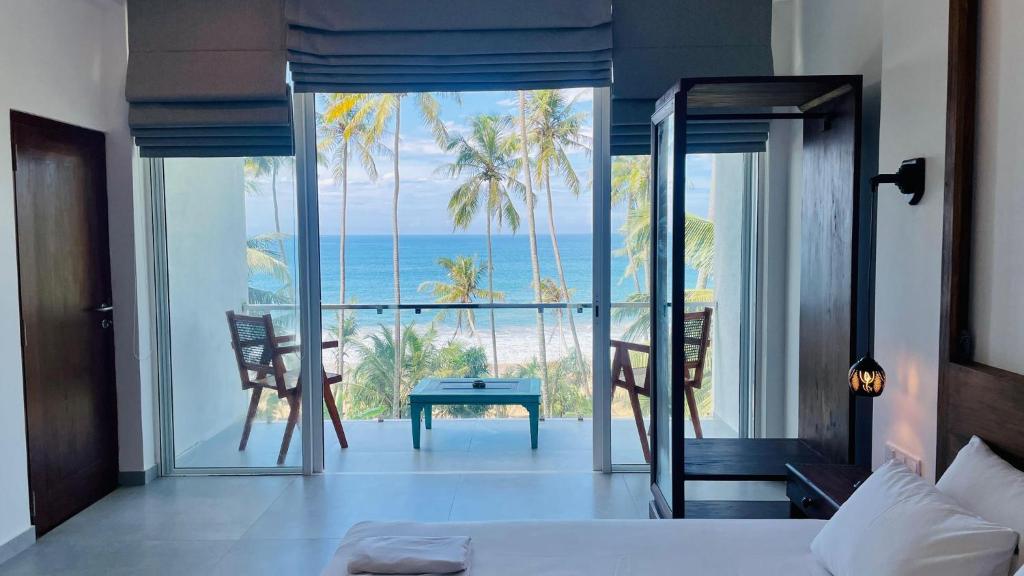 a bedroom with a bed and a view of the ocean at Villa LA Kurumba in Ambalangoda