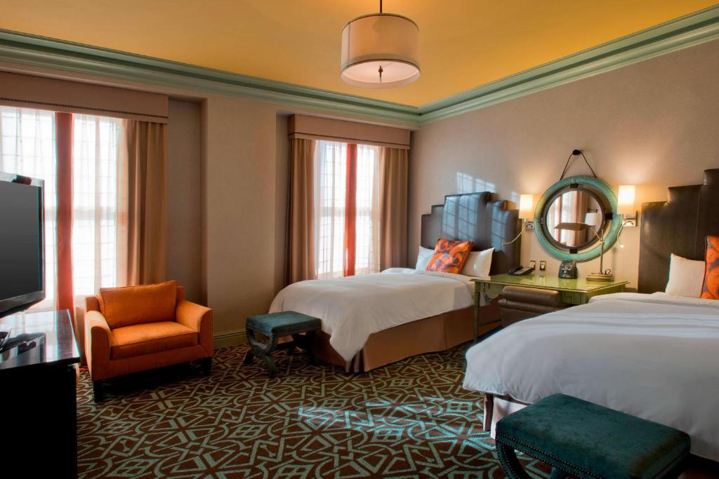 a hotel room with two beds and a chair at Hotel ICON, Autograph Collection in Houston