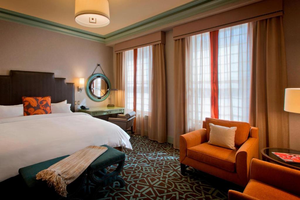 a hotel room with a bed and a chair at Hotel ICON, Autograph Collection in Houston