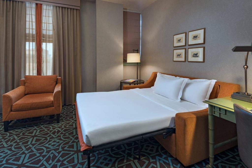 a hotel room with a large bed and a chair at Hotel ICON, Autograph Collection in Houston