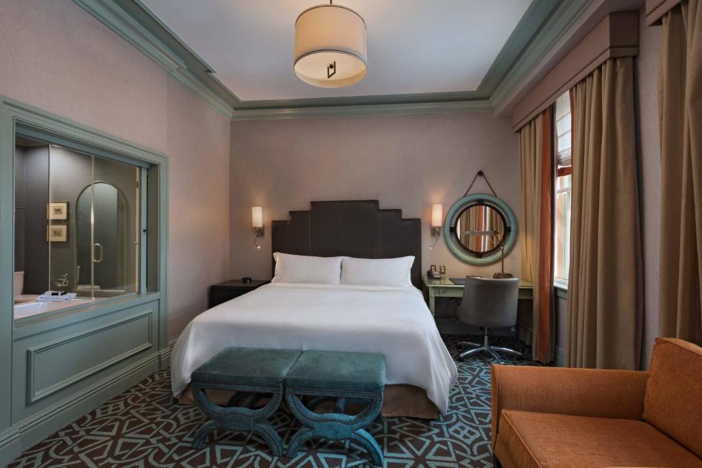 a bedroom with a bed and a couch and a sink at Hotel ICON, Autograph Collection in Houston