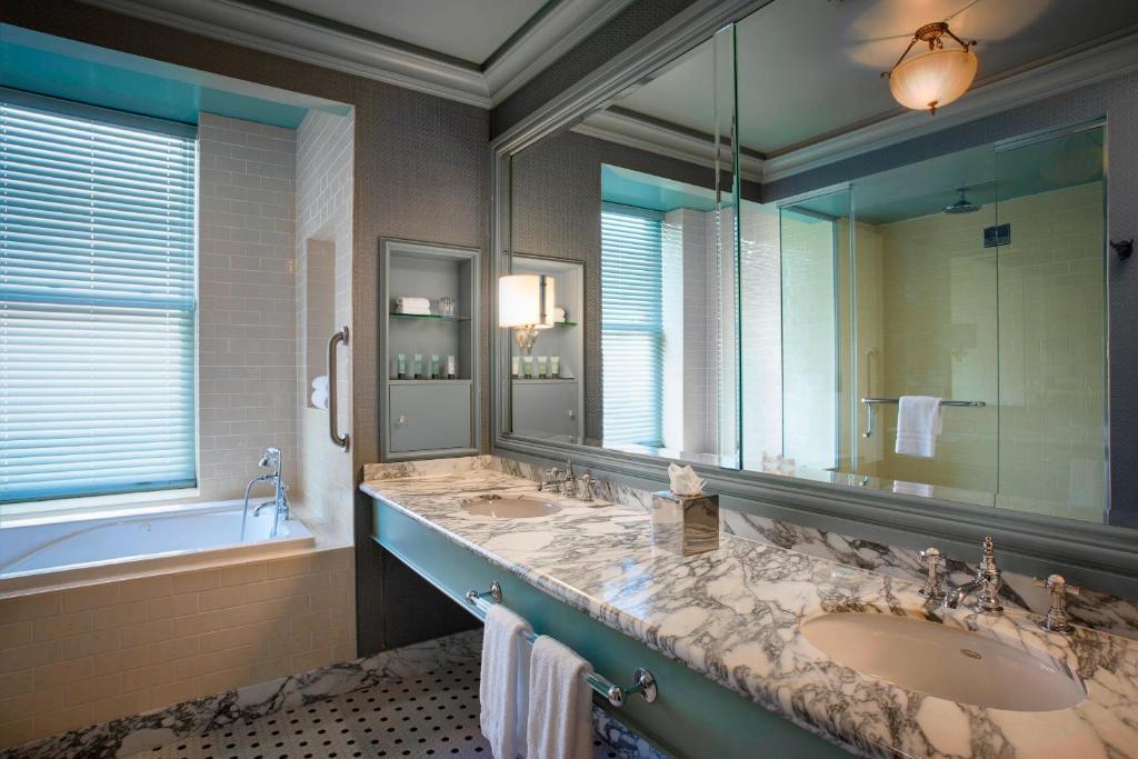 a bathroom with a sink and a large mirror at Hotel ICON, Autograph Collection in Houston