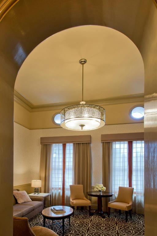 a living room with a couch and a chandelier at Hotel ICON, Autograph Collection in Houston