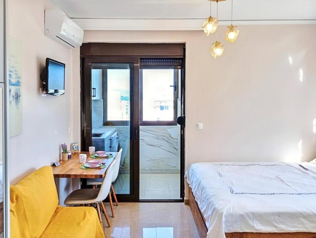 a bedroom with a bed and a desk and a bed and a table at 7-Modern city center studio with sea view! in Rhodes Town
