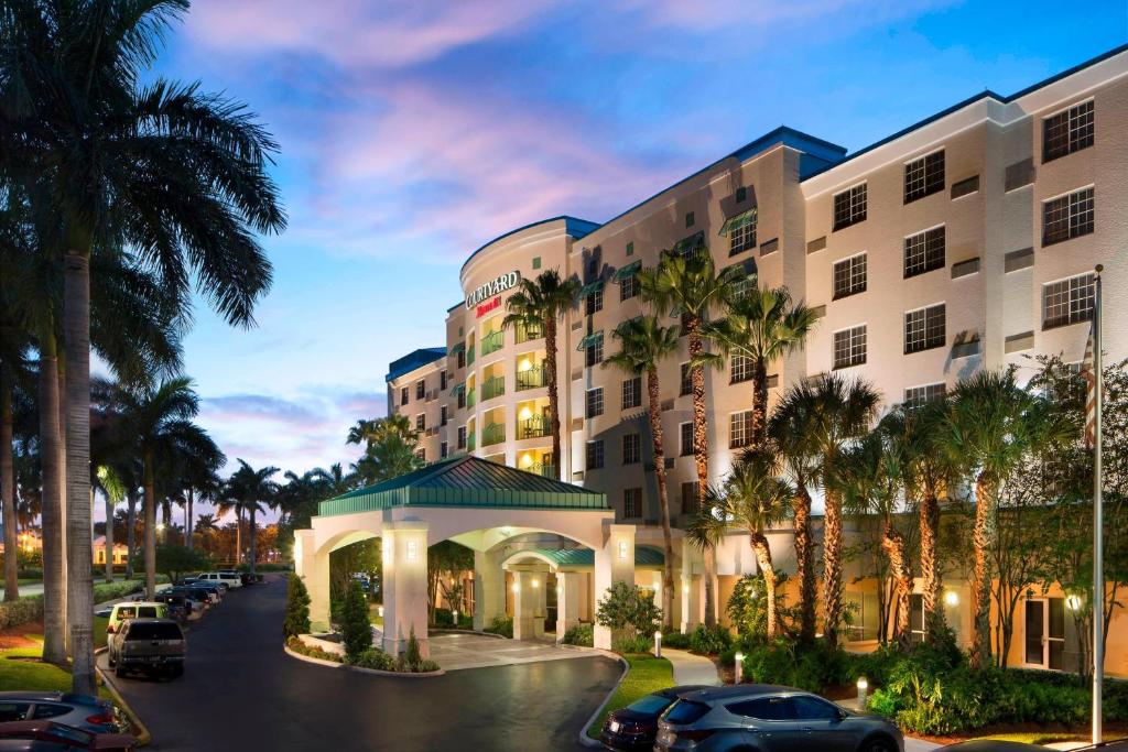 デイニア・ビーチにあるCourtyard by Marriott Fort Lauderdale Airport & Cruise Portの椰子の木のホテルの描写