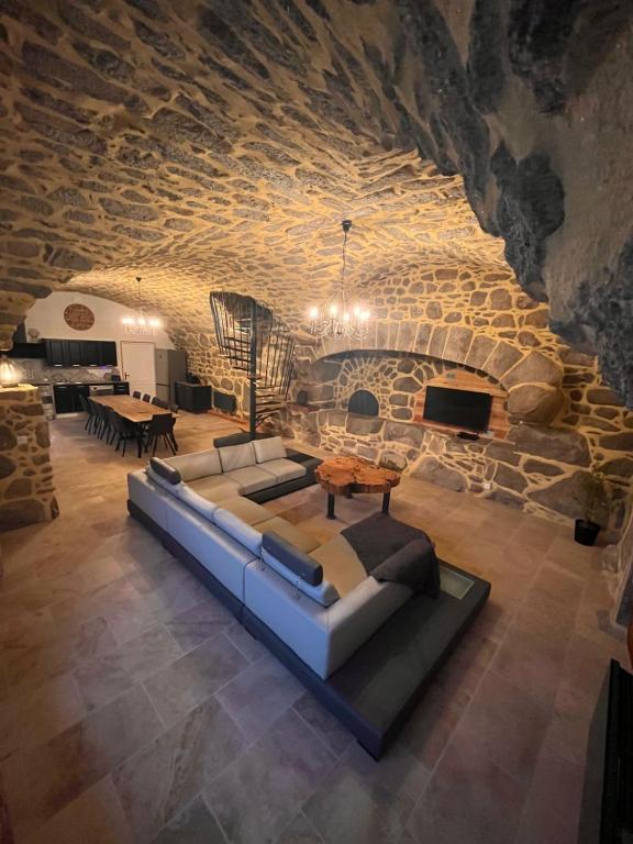 a living room with a couch and a stone wall at Le gîte du parayre in Lunac