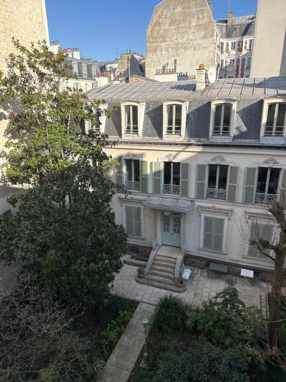 une grande maison blanche avec des escaliers dans une ville dans l'établissement Le Refuge Bohème, à Paris